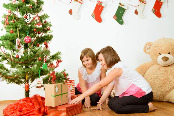 Дві дівчини задоволені своїми різдвяними подарунками — стокове фото