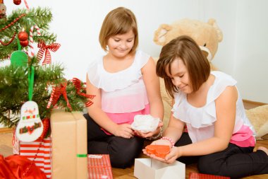 hediyeler ile Noel ağacı önünde iki kız