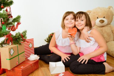 hediyeler ile Noel ağacı önünde iki kız