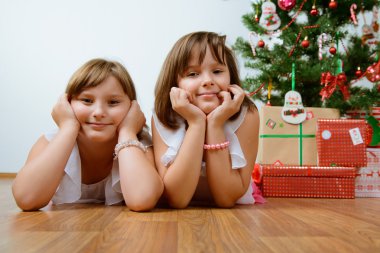 hediyeler ile Noel ağacı önünde iki kız
