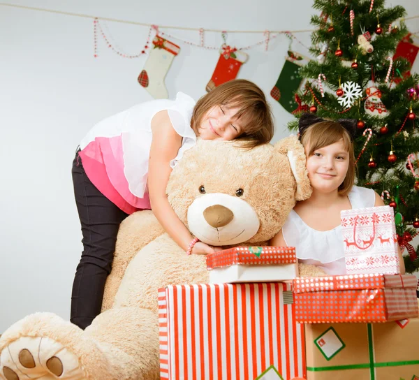 Δύο κορίτσια μπροστά από το χριστουγεννιάτικο δέντρο με τα δώρα — Φωτογραφία Αρχείου