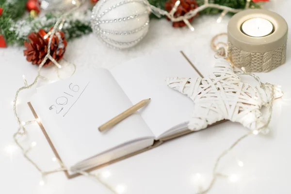 2016 written in notepad with a pencil,candle  and new year decor — Stock Photo, Image