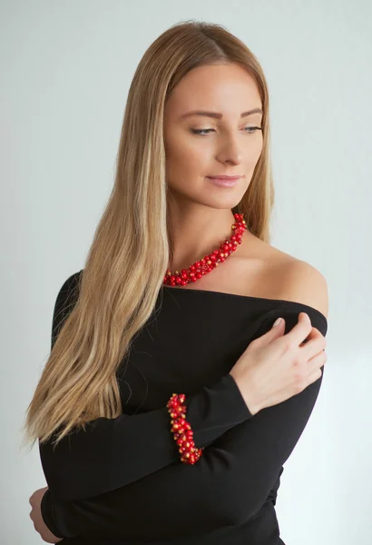 Bella donna in abito nero con collana e bracciale rosso — Foto Stock