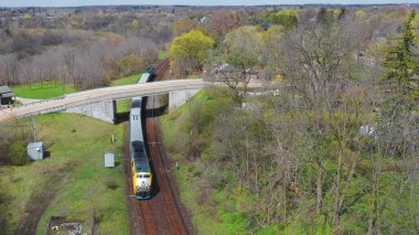 Virajı dönerken kasabaya giren bir yolcu treninin hava görüntüsü.