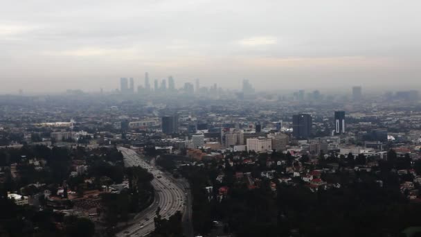 Een weergave van de schemering van de Los Angeles City Center met een drukke snelweg op de voorgrond — Stockvideo