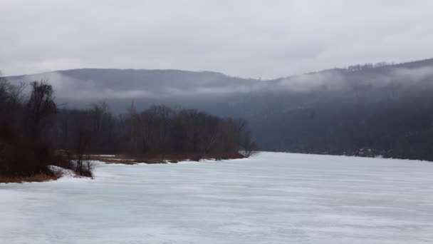 Временной туман, движущийся над замерзшей рекой — стоковое видео