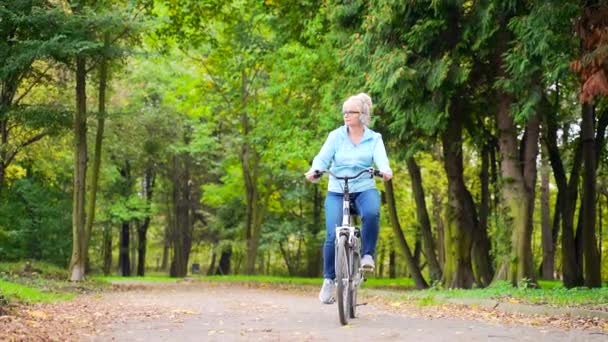 Mujer Mayor Feliz Los Paseos Auriculares Aparcar Una Bicicleta Escucha — Vídeos de Stock
