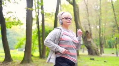 Bir ara sokakta, parkta ya da ormanda koşan ve kulaklıkla müzik dinleyen aktif bir son sınıf öğrencisi portresi. Spor giyim sektöründe yaşlı kadın fiziksel egzersizdir. Sabahları koşuyorum.