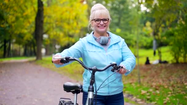 Szczęśliwa Seniorka Okularach Spaceruje Parku Rowerze Stara Rowerzystka Rowerem Retro — Wideo stockowe