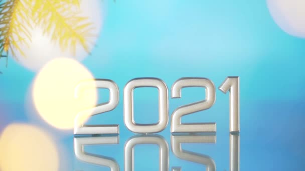 2021年末までに青を背景にガーランドと光のボケをぼかした モミの枝から ガラス面に2021年の装飾 — ストック動画
