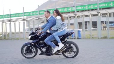  Motosiklet süren şık kot elbiseli genç ve mutlu bir çift. Motosiklet süren hayat tarzı adamı. Birbirini seven iki genç insan birlikte vakit geçirir. Sevgililer Günü