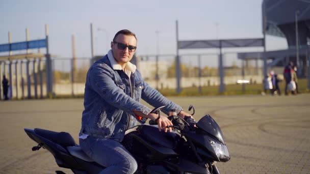 Uban Arka Planında Kendine Güvenen Şık Genç Erkek Motorcunun Portresi — Stok video