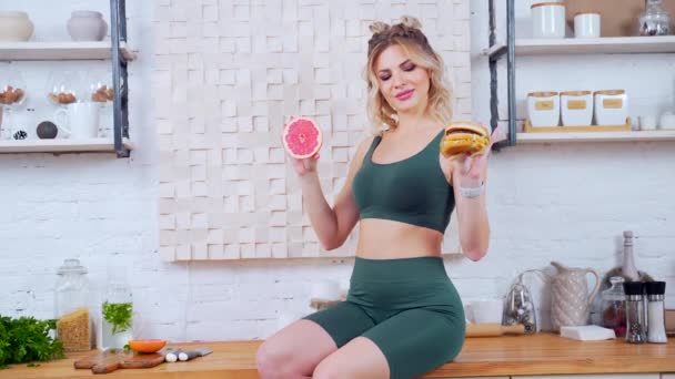 Retrato Jovem Esportes Fitness Mulher Cozinha Segurando Uma Fruta Hambúrguer — Vídeo de Stock