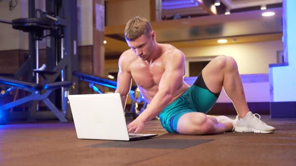 Νεαρός Άνδρας Γυμναστής Δείχνει Ασκήσεις Απευθείας Σύνδεση Χρησιμοποιώντας Φορητό Υπολογιστή — Αρχείο Βίντεο