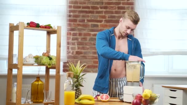 Junge Fitness Männliche Bodybuilder Athlet Bereitet Frischen Smoothie Mit Fruchtmixer — Stockvideo