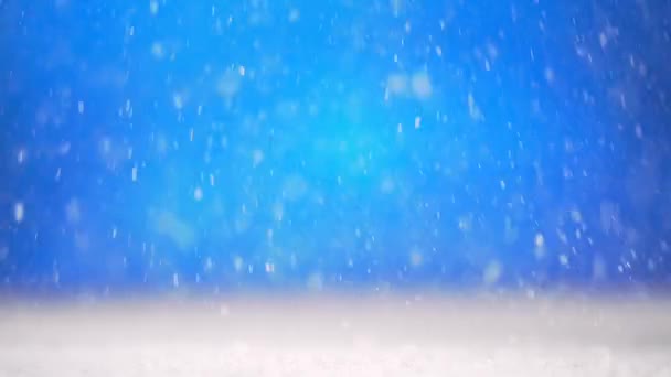 La neve vera sta cadendo su uno sfondo blu. Rallentatore. — Video Stock