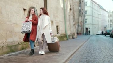 İki genç bayan turist ellerinde bir bavul ve hediye çantalarıyla eski kasabanın caddesinde yürüyorlar. Soğuk mevsimde iki kız paltolarla şehirde dolaşıyorlar. Avrupa