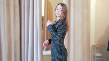 Bir giyim mağazasında takım elbise deneyen genç bir kız ya da aynanın önünde bir butik. Alışveriş merkezindeki çekici kadın indirimde. Kara Cuma