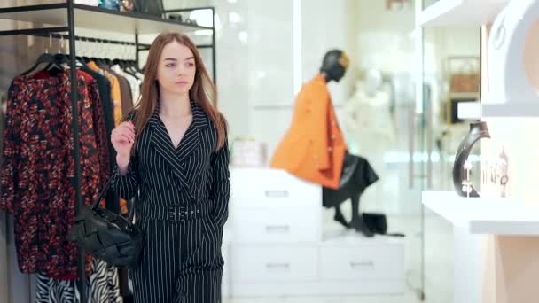 年轻的女购物者从购物中心的架子上检查衣服 一个购物狂女人在时尚精品店购物的肖像 黑色星期五漂亮女孩 服饰精品精品发售 — 图库视频影像