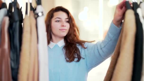 Mujer Atractiva Joven Examina Cuidadosamente Ropa Estante Percha Una Tienda — Vídeos de Stock