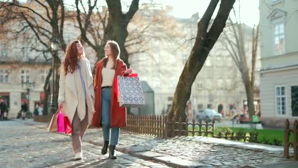 Dwie Szczęśliwe Młode Kobiety Spacerujące Mieście Zakupach Ulicy Miejskiej Płaszczach — Wideo stockowe