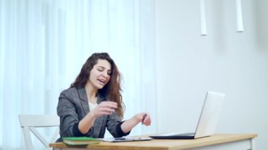 İş yerinde yorgun bir kadın, uzun süre dizüstü bilgisayarda oturarak, kötü duruş, oturma ve oturma sıkıntısı yüzünden boynunu çekiyor ve esniyor. Fibromiyalji ağrısı dizüstü bilgisayarda oturuyor.