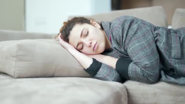 一个年轻的女人下班后筋疲力尽地睡在沙发上 熟睡的女学生躺在客厅的沙发上 辛苦的工作日 疲惫的美女感到缺乏动力 睡在室内 — 图库视频影像