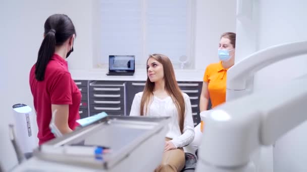 Uma Jovem Dentista Conversa Com Paciente Antes Iniciar Tratamento Procedimento — Vídeo de Stock