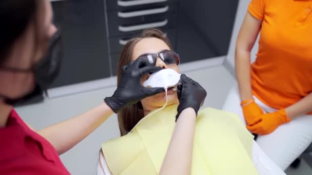 Procedimiento Blanqueamiento Dental Una Clínica Dental Dentista Asistente Femenino Utiliza — Vídeo de stock