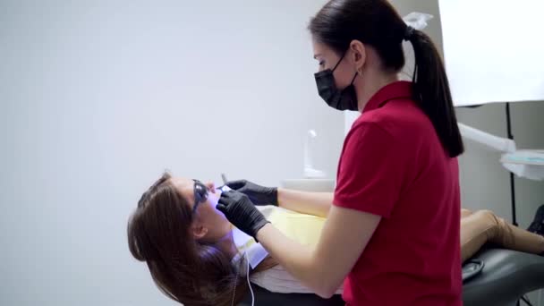 Procedimiento Blanqueamiento Dental Una Clínica Dental Dentista Asistente Femenino Utiliza — Vídeos de Stock