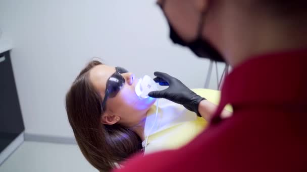 Procedimiento Blanqueamiento Dental Una Clínica Dental Dentista Asistente Femenino Utiliza — Vídeos de Stock