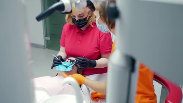 Κοντινό Πλάνο Μιας Γυναίκας Οδοντίατρος Εξετάζει Δόντια Μιας Νεαρής Γυναίκας — Αρχείο Βίντεο