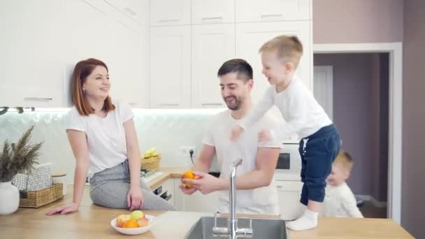 Cheerful Young Family Small Children Juggling Fruits Kitchen Two Little — Stock Video