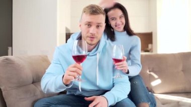 Neşeli, genç, evli bir çift internette arkadaşlarıyla ya da aileleriyle uzaktan konuşuyor ve cam şarapla kameraya bakıp el sallıyorlar. Mesafeyi kutlarken mutlu. Evde, kanepede.