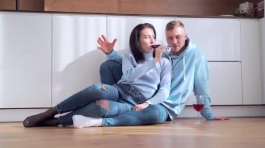 Genç, mutlu, evli bir çift yerde oturuyor. Bardakları şarapla tokuşturmak, yeni ev alımını kutlamak, başarılı mortgage yatırımları. Aile eşi flört etmekten zevk alıyor. Birlikte bir dairede vakit geçirin.