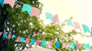 Doğum günü kutlaması dışında dekorasyon. Ağaçların arasında asılı pastel kiraz kuşu bayrakları. Yaz bahçesi partisi. Açık hava, düğün. Yaz ortası, festa junina konsepti. Doğal bulanık arkaplan, güneşli sis.