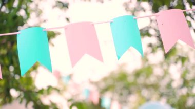 Doğum günü kutlaması dışında dekorasyon. Ağaçların arasında asılı pastel kiraz kuşu bayrakları. Yaz bahçesi partisi. Açık hava, düğün. Yaz ortası, festa junina konsepti. Doğal bulanık arkaplan, güneşli sis.