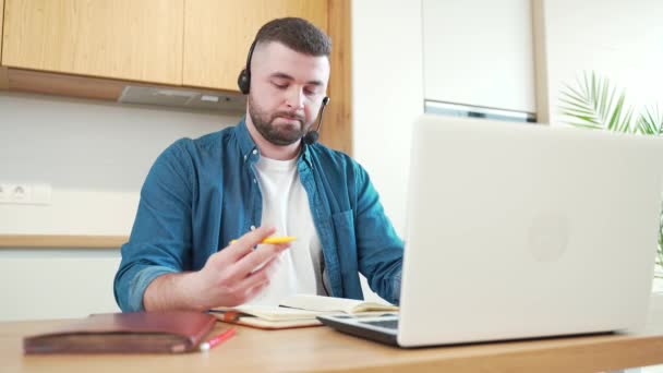 Barbudo Joven Casual Auriculares Hablando Webcam Mirando Portátil Hacer Notas — Vídeos de Stock