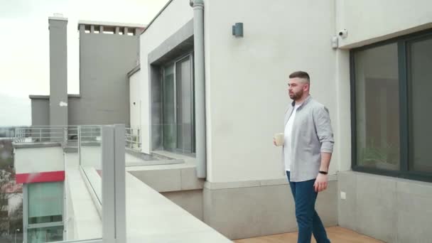 Genç Yakışıklı Sakallı Adam Modern Balkonda Duruyor Terasta Şehir Manzarasının — Stok video