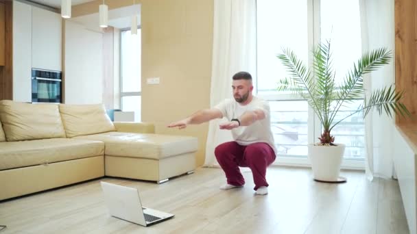 Joven Barbudo Guapo Haciendo Ejercicios Físicos Sentadillas Pijama Casa Sala — Vídeos de Stock