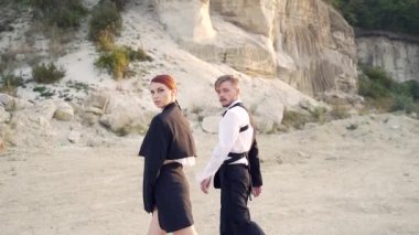 Profesyonel moda dansçıları ve modelleri. Açık hava moda gösterisi. Sokaktaki genç bir çiftin modern tasarımı. Bir erkek ve bir kadın sanat gösterisi. Ağır çekim. Dışarıda moda gösteren şık insanlar.