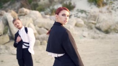 Profesyonel moda dansçıları ve modelleri. Açık hava moda gösterisi. Sokaktaki genç bir çiftin modern tasarımı. Bir erkek ve bir kadın sanat gösterisi. Ağır çekim. Dışarıda moda gösteren şık insanlar.