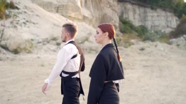 Profesyonel moda dansçıları ve modelleri. Açık hava moda gösterisi. Sokaktaki genç bir çiftin modern tasarımı. Bir erkek ve bir kadın sanat gösterisi. Ağır çekim. Dışarıda moda gösteren şık insanlar.