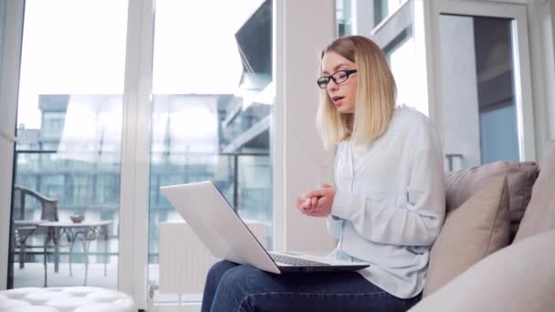 Genç Bir Kadını Internette Çalışıyor Bir Kanepede Dizüstü Bilgisayarla Oturuyor — Stok video