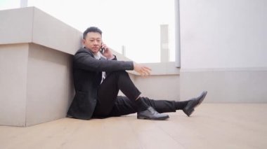 Genç Asyalı bunalımlı adam ofis binasının yanındaki açık havada oturuyor. Üzgün erkek işadamı mali kriz ve karantina yüzünden işini kaybetti. İş adamının sorunları var.