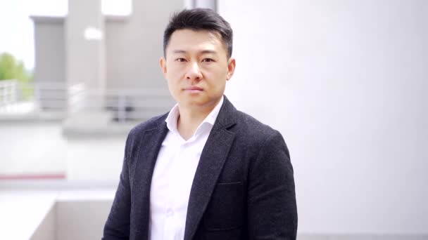 Porträt Selbstbewusster Asiatischer Geschäftsmann Der Vor Dem Hintergrund Moderner Bürogebäude — Stockvideo