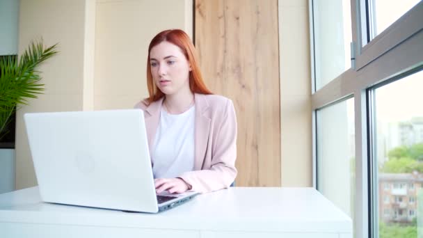 Junge Rothaarige Büroangestellte Die Drinnen Computer Oder Laptop Schreibtisch Arbeitet — Stockvideo