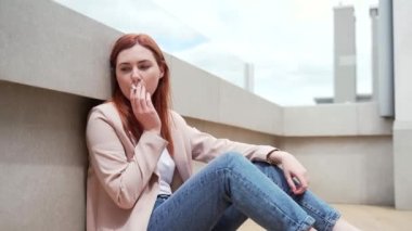 Depresyonda olan genç bir kadın ya işini kaybetti ya da sigara içerken maddi sorunlar yaşıyor. Yalnız kız öğrenci iş yerinde stres yaşıyor. Dışarıda kederli işsiz bir bayan.