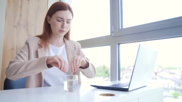 年轻的高加索女人在工作场所喝水止疼药 女商人坐在写字台前 患有慢性疾病 痛得厉害女性使用毒品 对药物的依赖 — 图库视频影像