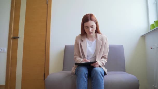 Ung Kaukasisk Kvinna Sitter Väntrummet Hallen Och Fyller Ett Frågeformulär — Stockvideo